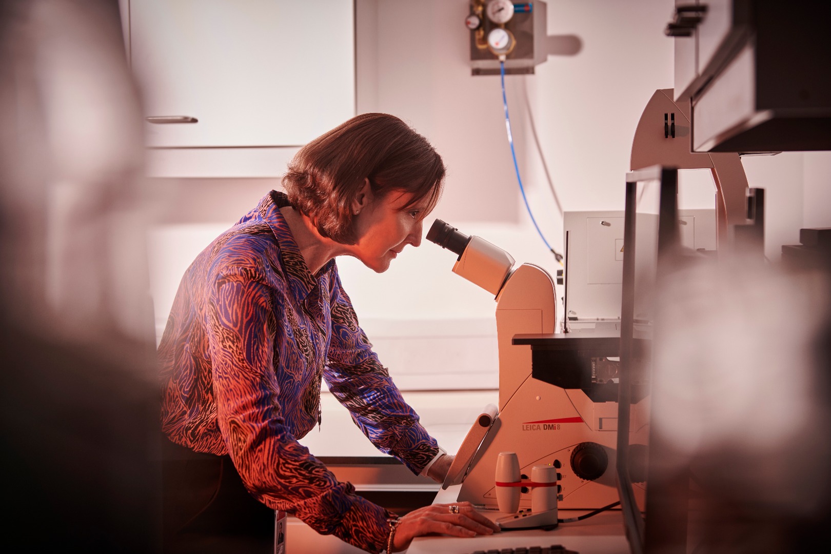 Dr Carolyn Porter looking into a microscope