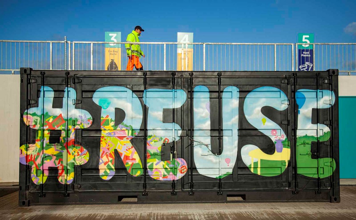 #reuse written in colourful graffiti showing a workman wearing high visibility jacket and trousers