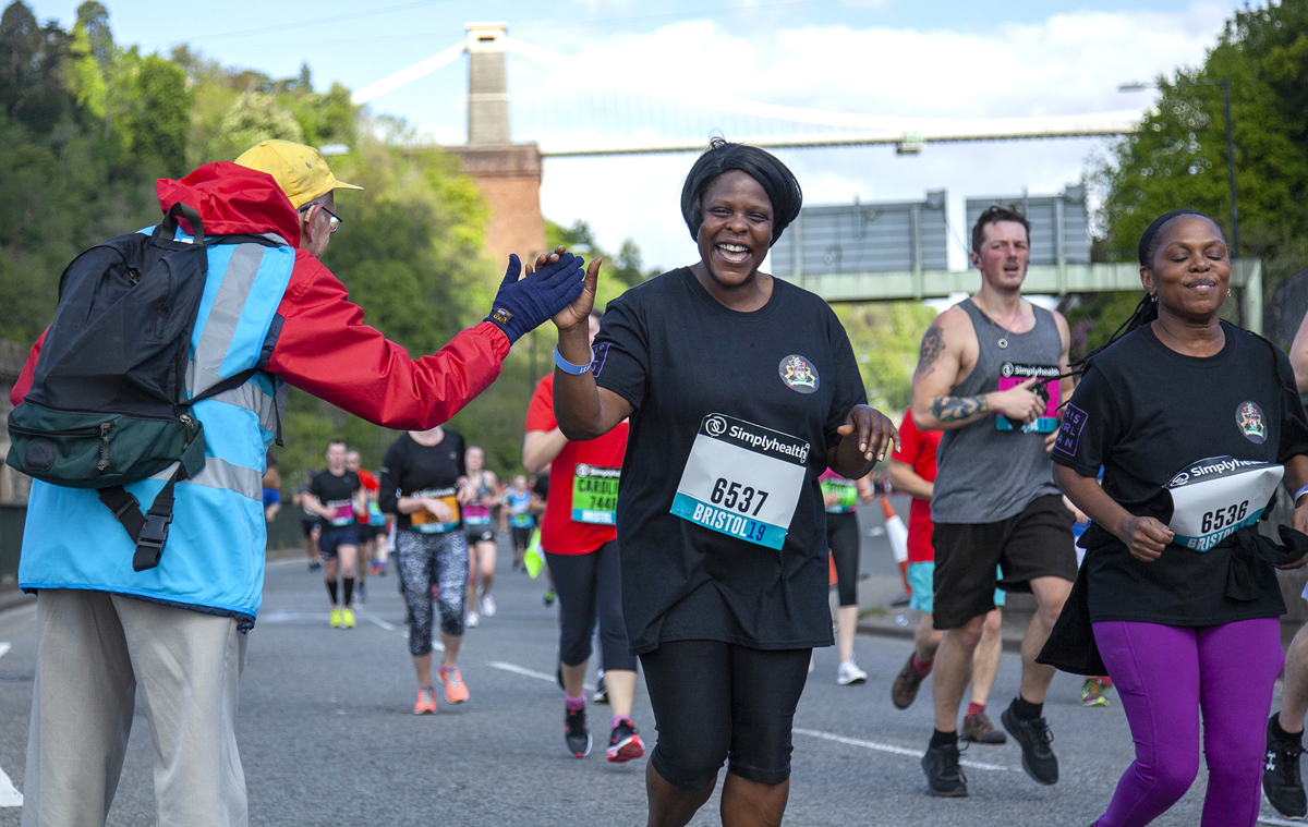 Woman running a 10K race with the suspension bridge in the background