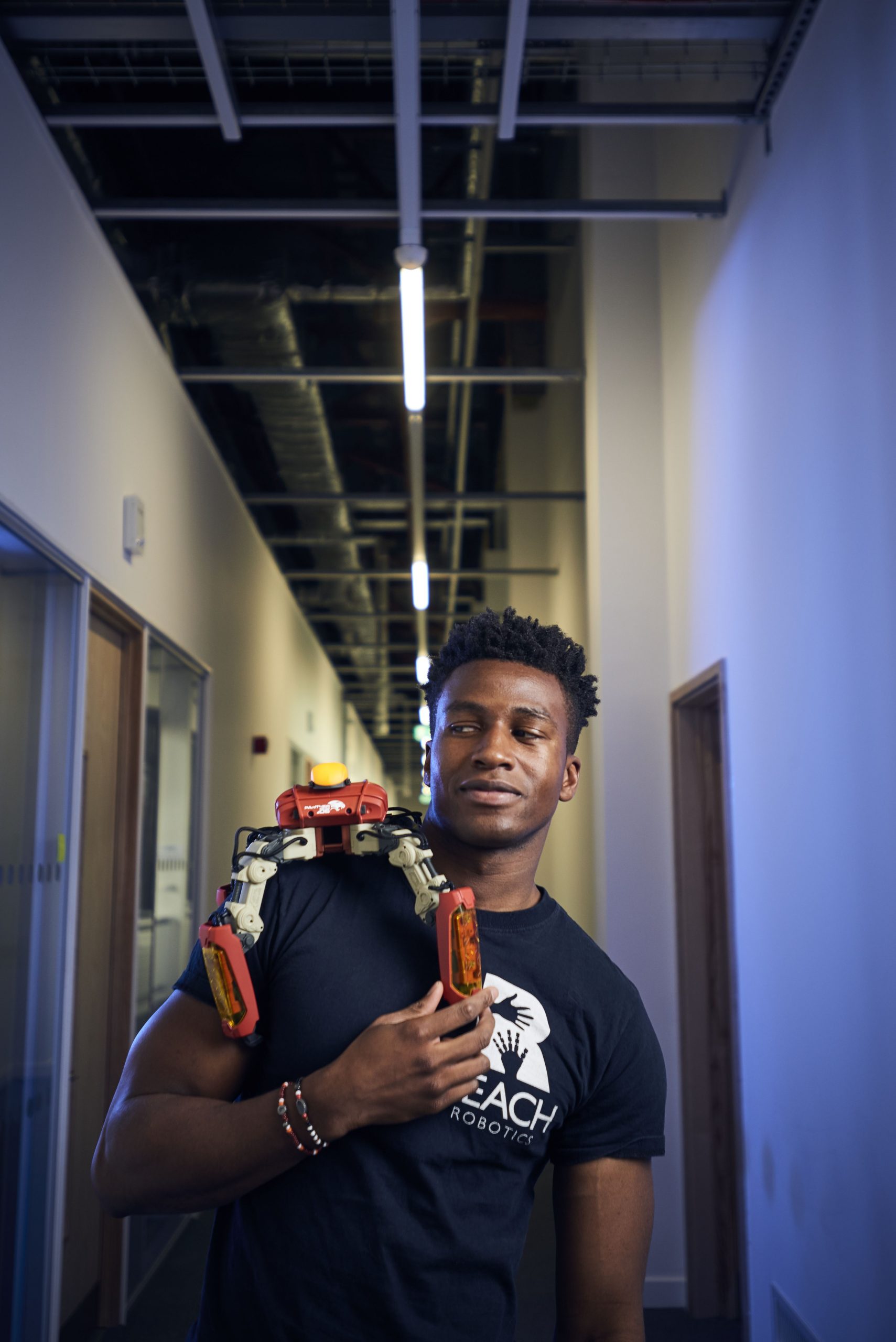 Silas Adekunle holding a robot on his shoulder