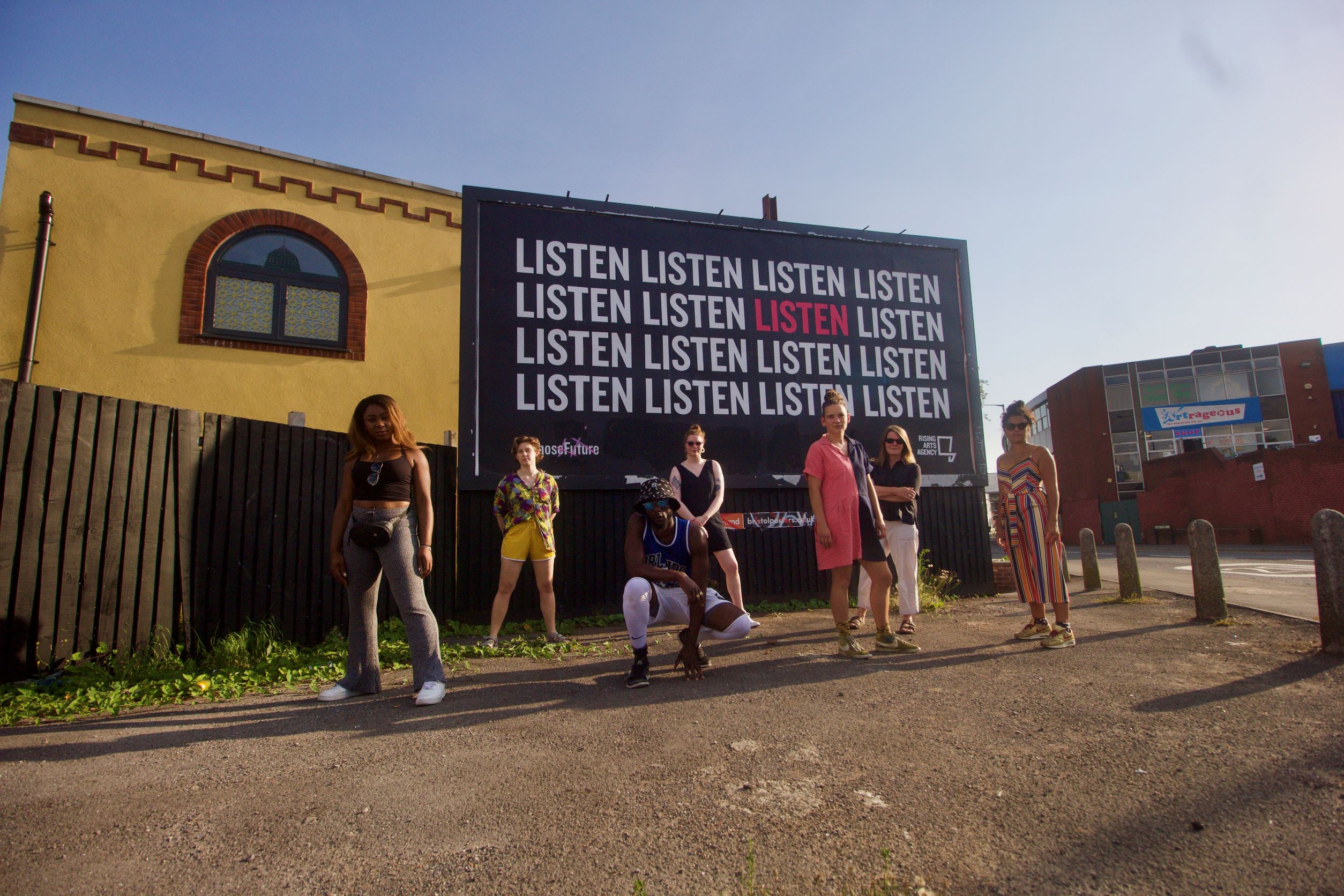 Whose future members standing in front of billboard