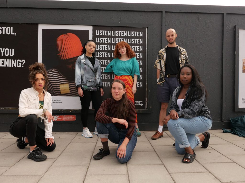 Rising Arts team in front of posters