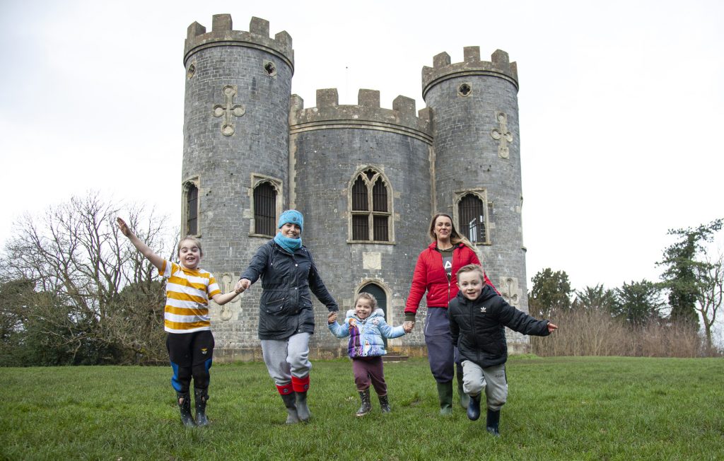 Adults and children running playfully with Blaise castle in the background